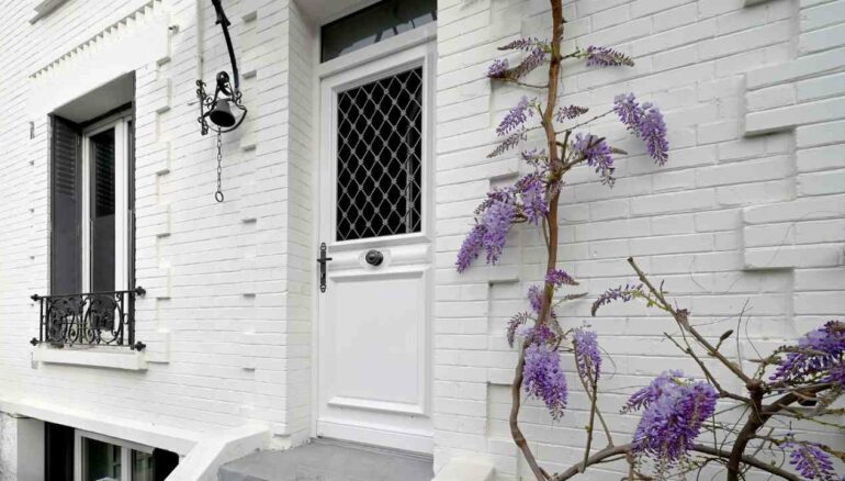 Porte Lutece vitrée avec grille sur maison de ville en briques blanches