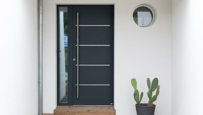 Porte entrée contemporaine avec barre de tirage sur une maison moderne modèle Cotim 11