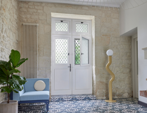 une porte d'entrée en bois avec double vantaux et un vitrage avec chassis ouvrant dans un intérieur de maison rénové