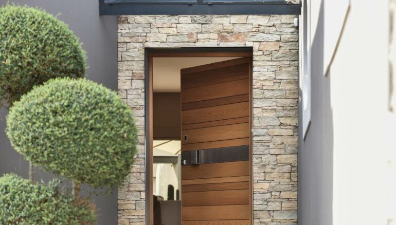 porte d'entrée en bois sur une maison moderne avec parement de pierre
