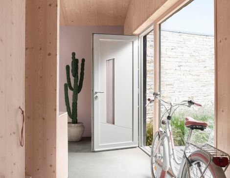 entrée de maison avec une porte d'entrée pvc blanche vitrée dans un intérieur de maison lumineux aux couleurs sobres