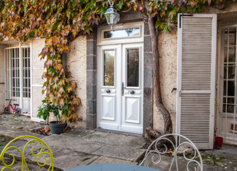 Façade de maison avec du lierre et une porte d'entrée blanche zilten