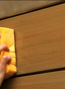 Personne en train de nettoyer une porte d'entrée en bois zilten