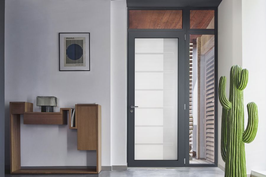 Porte d'entrée vitrée moderne et design avec un fixe et une imposte vitrée, au sein d'une maison contemporaine