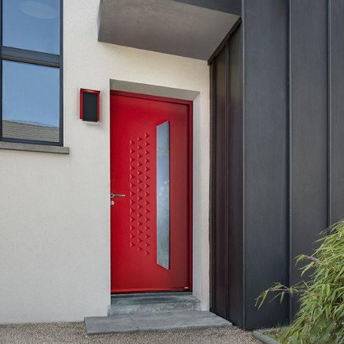 porte d'entrée rouge en acier, vue extérieure. La porte possède un vitrage et des décors contemporains.