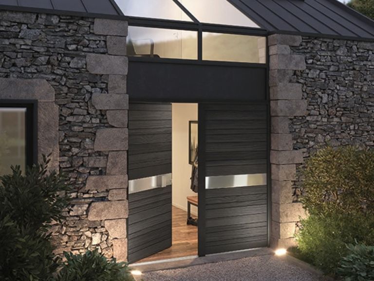 Porte moderne en bois sur maison en pierre.