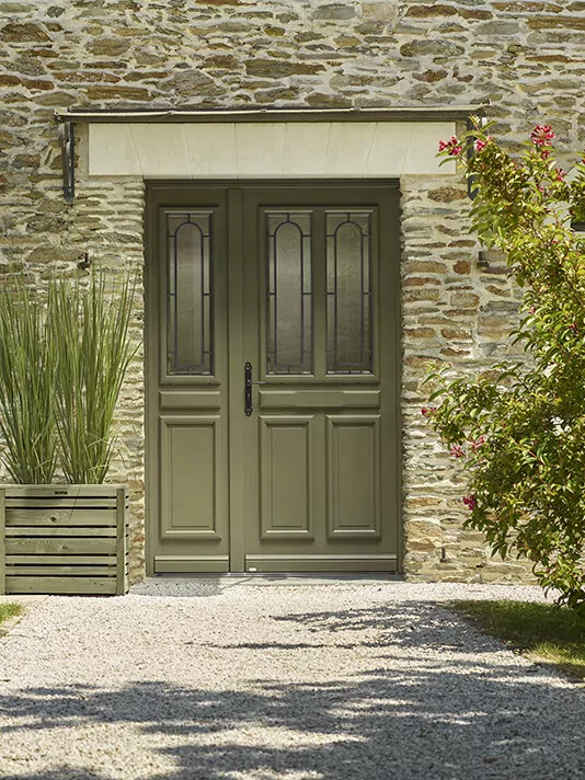 Porte d'entrée lunel sur une façade de maison en pierre style campagne