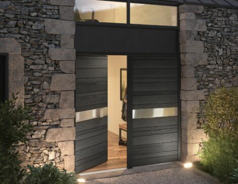porte d'entrée en bois moderne modèle nativ fusion shu sugi ban sur une façade de maison en pierre