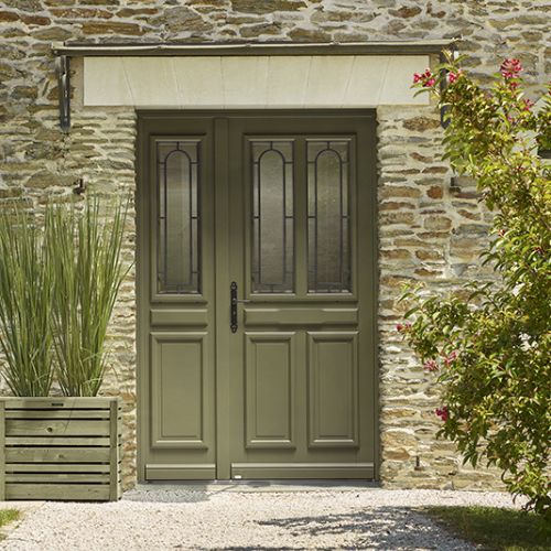 porte d'entrée en bois avec un vitrage, sur une façade de maison en pierre