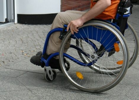 une personne en fauteuil roulant proche d'un seuil de porte d'entrée