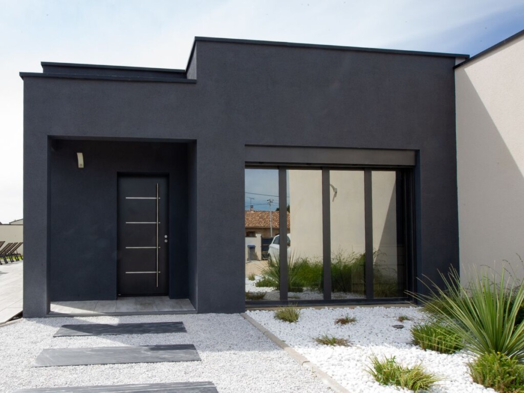 aménagement extérieure devant une maison moderne avec une allée de gravier et des dalles en ardoise