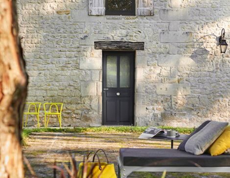 porte d'entrée PVC gris anthracite dans un style traditionnel sur une maison en pierre