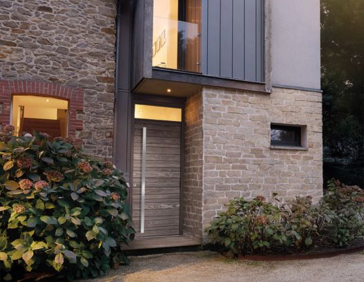 maison en pierre avec une porte d'entrée en bois contemporaine nativ z3 silver de zilten