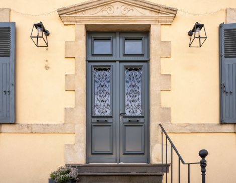 porte d'entrée en bois à l'ancienne avec une grille et des moulures